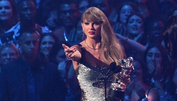 Taylor Swift accepting a Moonperson during Wednesday's VMAs