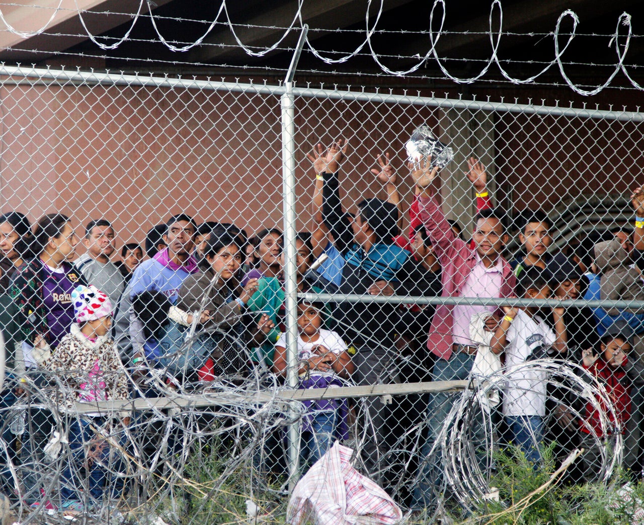 In this March 27, 2019, file photo, Central American migrants wait for food in a pen erected by U.S. Customs and Border Protection in El Paso, Texas.