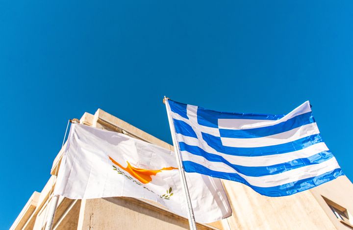 Cypriot and Greek flags flying against blue sky in Paphos, Cyprus - September, 2023