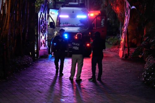 Federal agents stand at the entrance to a property belonging to rapper Sean "Diddy" Combs on March 25 on Star Island in Miami Beach. Two of his properties in Los Angeles and Miami were searched by Homeland Security Investigations agents and other law enforcement as part of a New York case.