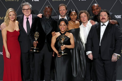 The cast of "The Bear" poses at the Emmys, left to right: Abby Elliott, Oliver Platt, Edwin Lee Gibson, Ebon Moss-Bachrach, Liza Colón-Zayas, Ayo Edebiri, Jeremy Allen White, Lionel Boyce, and Matty Matheson.