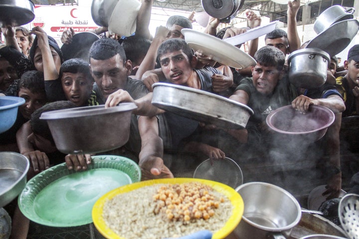 Palestinians, including children, wait in Gaza City as aid workers distribute food amid mass starvation in the territory on Sept. 12, 2024.