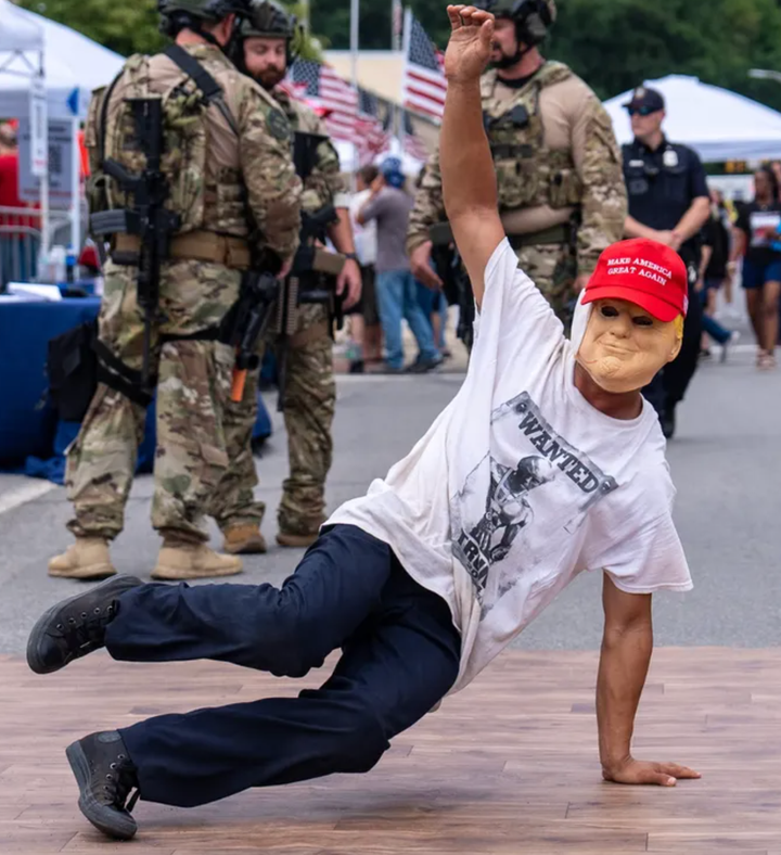 トランプマスクをつけてブレイクダンスを踊る人＝ペンシルベニア州ジョンズタウン