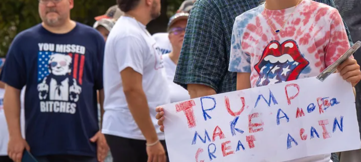 トランプ氏の選挙集会への列に並び、「Make America Great Again」と書かれた手作りのボードを持つ子ども＝ペンシルベニア州ジョンズタウン