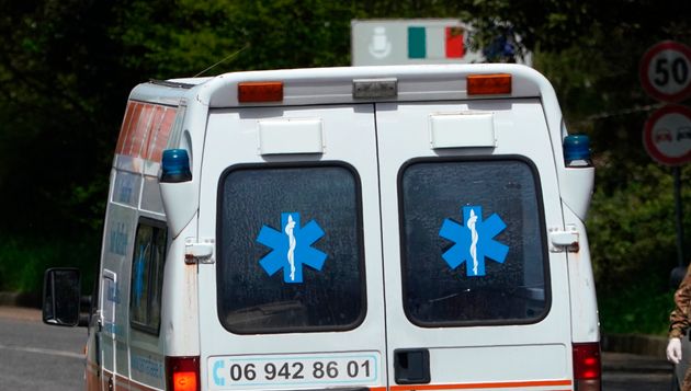 An ambulance passes a road block on a road leading to the San Raffaele health care and hospice structure after, according to reports, over 70 people inside tested positive to the new coronavirus, in Rocca di Papa, near Rome, Friday, April 17, 2020. (AP Photo/Andrew Medichini)