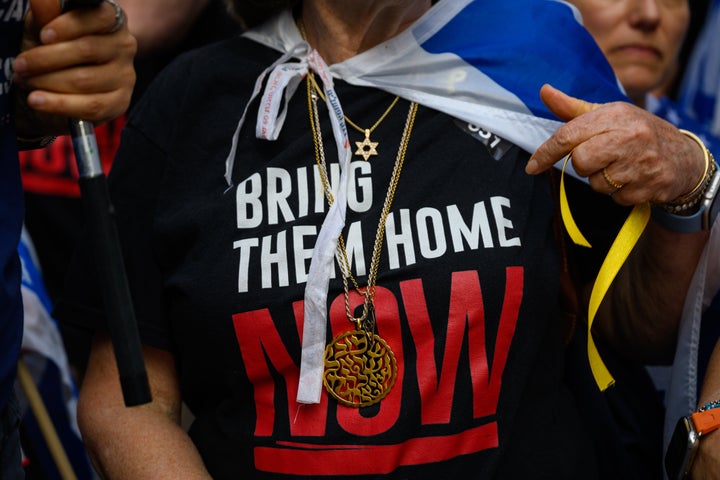 A woman points to her large prayer necklace and "Bring Them Home Now" T-shirt while participating in a rally outside the United Nations Headquarters in New York City that calls on the body to do more to release Hamas' hostages ahead of the General Assembly next week on September 20, 2024. 