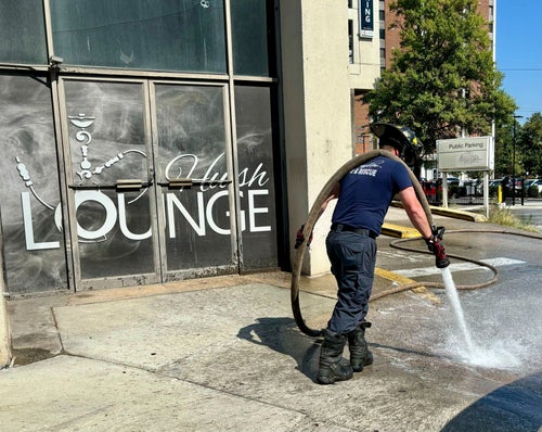 A firefighter cleans blood stains off the sidewalk outside a nightclub in Birmingham, Ala. on Sept. 22, 2024, after a mass shooting took place.
