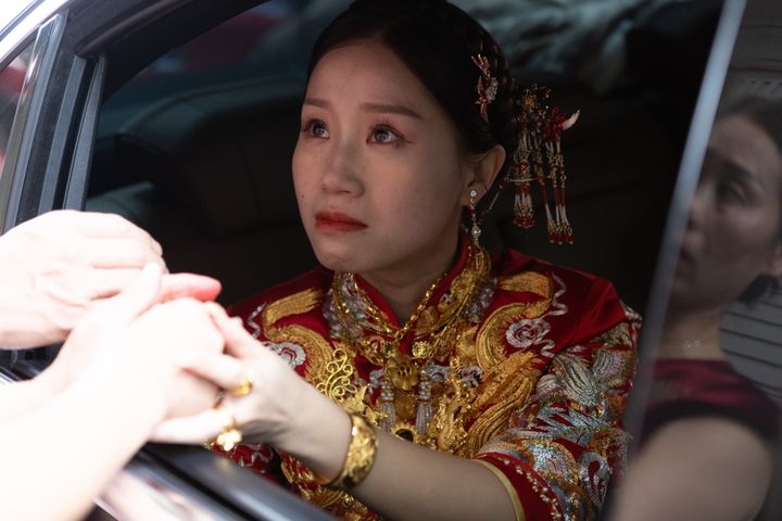 A beautiful Chinese bride says goodbye to her mother in a car