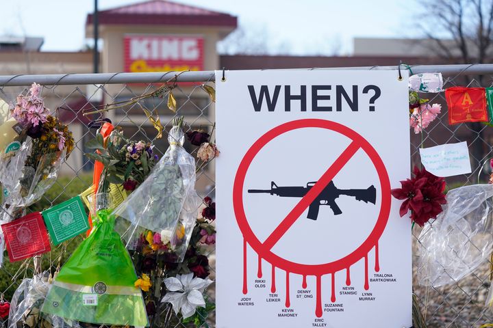 An einem provisorischen Zaun rund um den Parkplatz vor dem Lebensmittelgeschäft King Soopers, wo Ende März 2021, am 9. April 2021, in Boulder, Colorado, bei einer Massenerschießung zehn Menschen getötet wurden, sind Gedenkmünzen aufgehängt. (AP Photo/David Zalubowski, Datei)