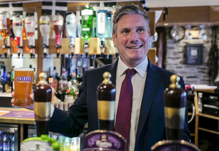 Keir Starmer pulls a pint of "Tribute" behind the bar before meeting with local business leaders at the Chainlocker pub in Falmouth.