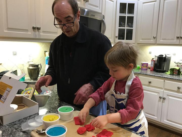 The authors father and her son play together in the kitchen.