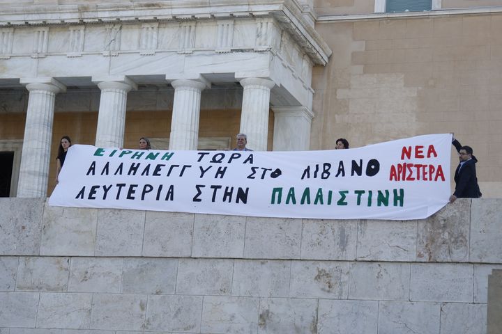 Το πανό που ύψωσαν στην Βουλή βουλευτές της Νέας Αριστερας: Ειρήνη τώρα. Αλληλεγγύη στον Λίβανο. Λευτεριά στην Παλαιστίνη"