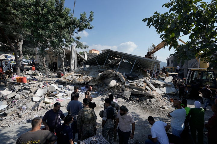 Residents and emergency workers arrive at the scene of an Israeli airstrike in the town of Maisara, north of Beirut, Wednesday, Sept. 25, 2024. (AP Photo/Bilal Hussein)