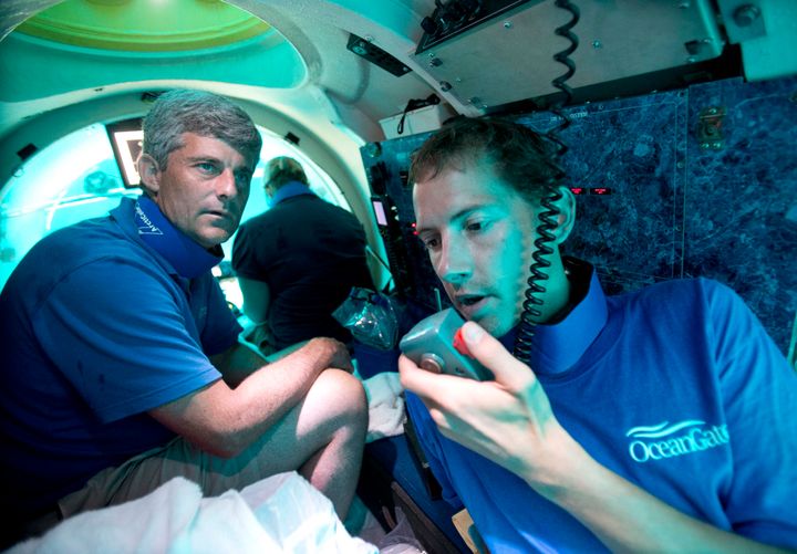 Submersible pilot Randy Holt, right, communicates with the support boat as he and Stockton Rush, left, CEO and Co-Founder of OceanGate, dive in the company's submersible, "Antipodes," about three miles off the coast of Fort Lauderdale, Fla., June 28, 2013. (AP Photo/Wilfredo Lee, File)