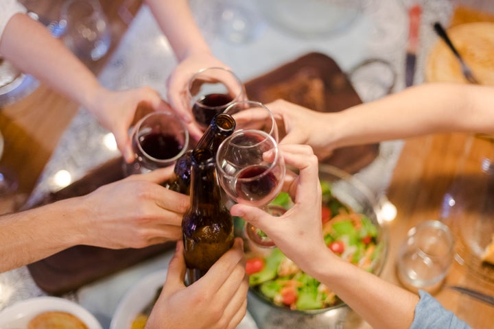 Close up friends toasting over barbecue dinner table