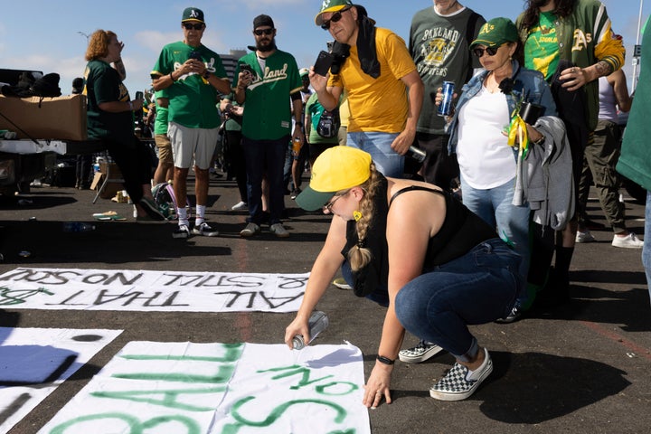 Michelle Leon malt ein Schild vor dem Oakland Coliseum vor einem Baseballspiel zwischen den Oakland Athletics und den Texas Rangers am Donnerstag, 26. September 2024, in Oakland, Kalifornien (AP Photo/Benjamin Fanjoy)