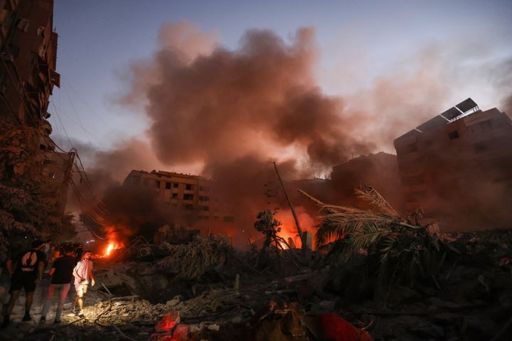 Smoke rises from the smouldering rubble as people gather at the scene of Israeli air strikes in the Haret Hreik neighbourhood of Beirut's southern suburbs on September 27, 2024. (Photo by IBRAHIM AMRO/AFP via Getty Images)