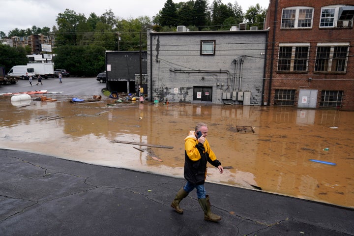 Ein Mann geht in der Nähe eines überschwemmten Gebiets in der Nähe des Swannanoa River nach dem Hurrikan Helen, Freitag, 27. September 2024, in Asheville, North Carolina (AP Photo/Erik Verduzco).