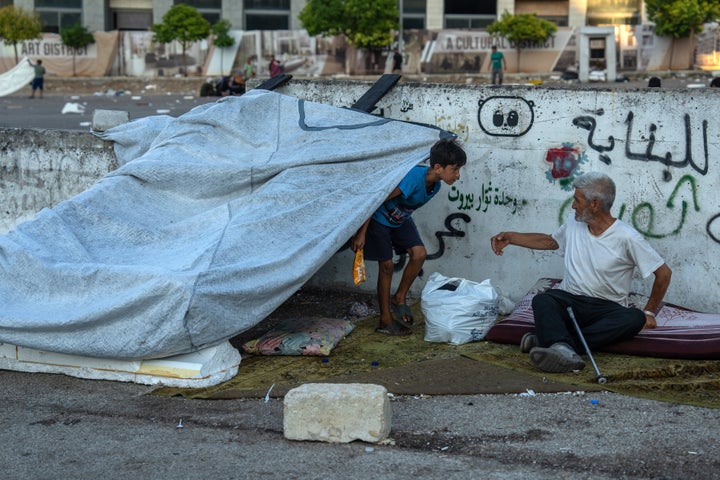 A man and young boy shelter in Martyrs' Square after being displaced by Israeli airstrikes on Sunday in Beirut, Lebanon. Lebanese Prime Minister Najib Mikati said that an estimated one million people have been forcibly displaced in the country by Israel's attacks.