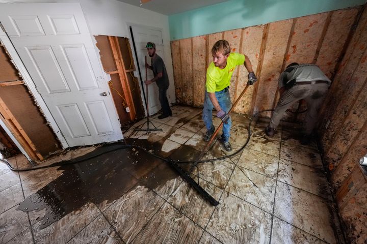 Arbeiter säubern und zerstören Grundstücke, die nach Hurrikan Helen vom Regenwasser überflutet wurden, in Steinhatchee, Florida, Sonntag, 29. September 2024. (AP Photo/Gerald Herbert)