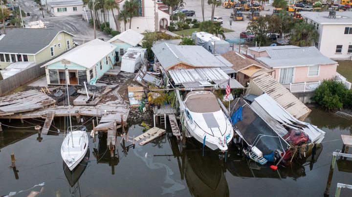 Diese Drohnenaufnahme aus der Luft zeigt beschädigte Häuser und ein Fahrzeug, das nach der Sturmflut von Hurrikan Helen am Samstag, 28. September 2024, in Madeira Beach, Florida, ins Wasser stürzte. (Luis Santana/Tampa Bay Times via AP)