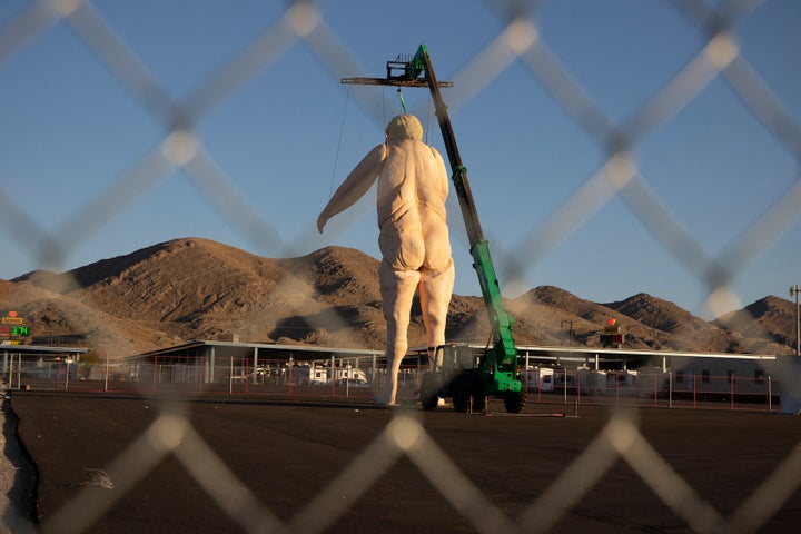 The statue is titled "Crooked and Obscene."