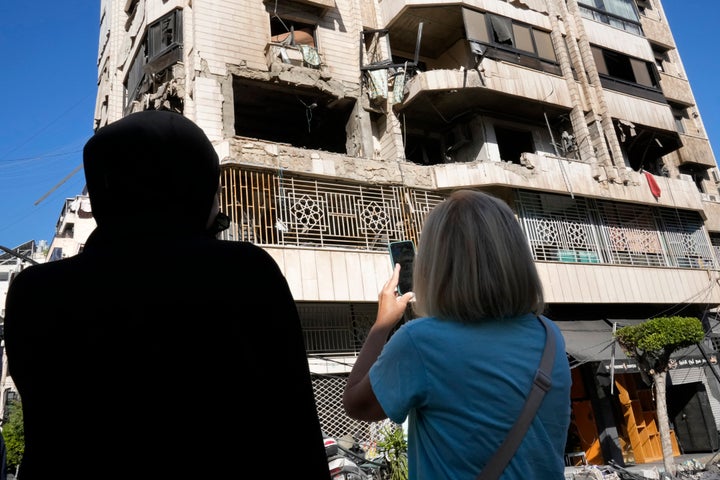 Λιβανέζες γυναίκες στέκονται μπροστά από ένα διαμέρισμα σε πολυώροφο κτίριο που χτυπήθηκε από ισραηλινή αεροπορική επιδρομή, στην κεντρική Βηρυτό του Λιβάνου, Πέμπτη 3 Οκτωβρίου 2024. (AP Photo/Hussein Malla)