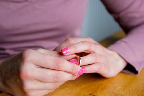 A woman taking off her wedding ring.