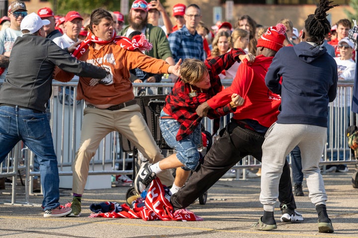 Vendors selling Trump merchandise fight with each other before a campaign event with Donald Trump.