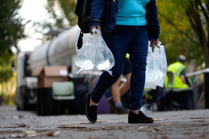 Eine Person hält Säcke mit Frischwasser in der Hand, nachdem sie diese nach dem Hurrikan Helen am Mittwoch, dem 2. Oktober 2024, in Asheville, North Carolina, aus einem Tanker gefüllt hat (AP Photo/Jeff Roberson).