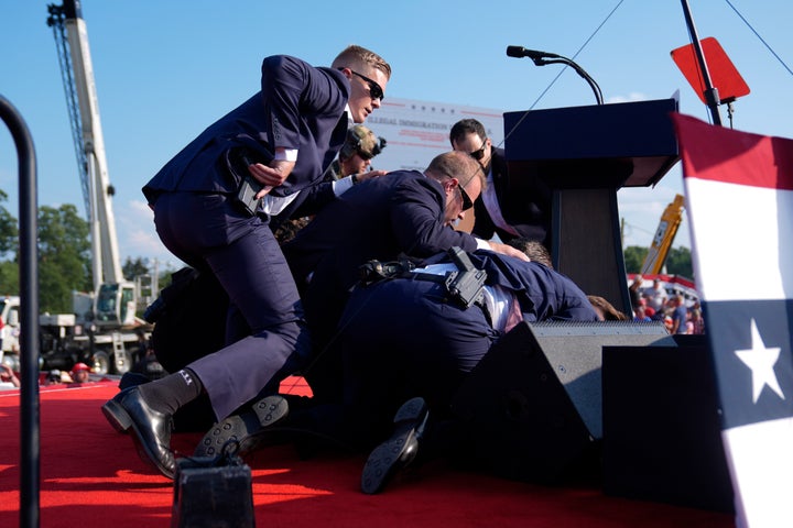 Der republikanische Präsidentschaftskandidat, der ehemalige Präsident Donald Trump, wird bei einer Wahlkampfveranstaltung am Samstag, dem 13. Juli 2024, in Butler, Pennsylvania, von Agenten des US-Geheimdienstes abgedeckt. (AP Photo/Evan Vucci)