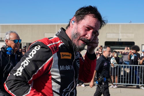Keanu Reeves walks in the garage area following his pro racing debut at Indianapolis Motor Speedway on Oct. 5.