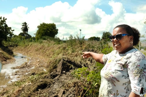 Diana Santi, a local store owner in the El Coquí neighborhood of Salinas, Puerto Rico, points to where the floodwaters gushed during the last major hurricane.