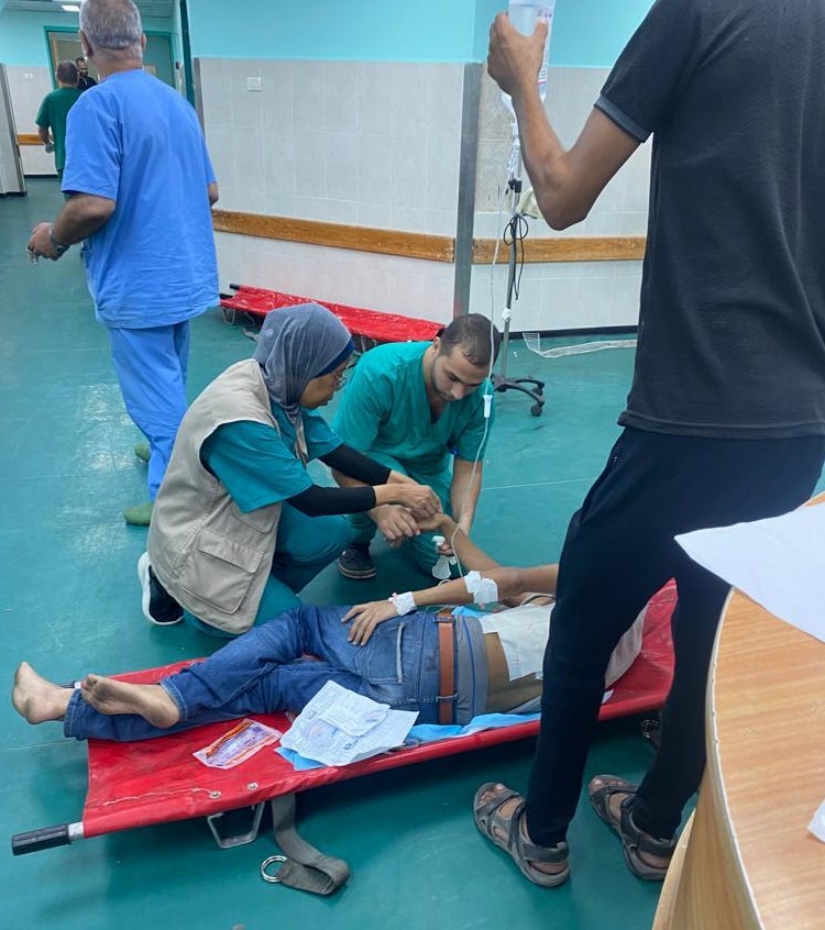 Rajaa Musleh, a trained nurse who now works as Gaza's country director for MedGlobal, helps treat a patient at a clinic in Gaza last fall.