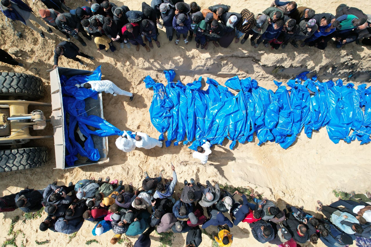 The bodies of 47 Palestinians delivered by Israeli forces from the Kerem Shalom border crossing are buried in a mass grave March 7 after funeral prayers in Rafah, Gaza.