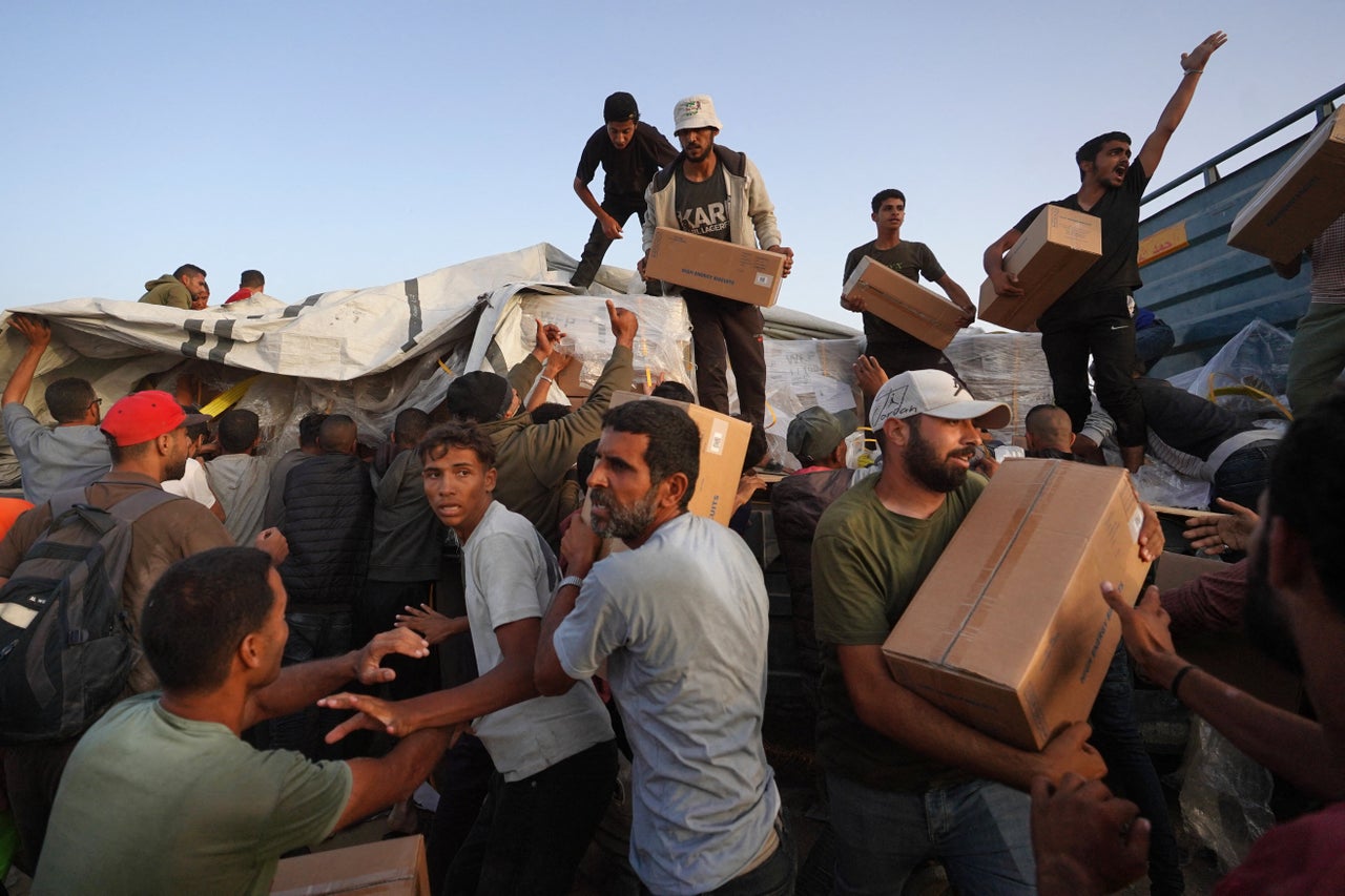 Palestinians carry boxes of humanitarian aid on May 18 after rushing the trucks from the U.S.-built Trident Pier near Nuseirat in the central Gaza Strip.