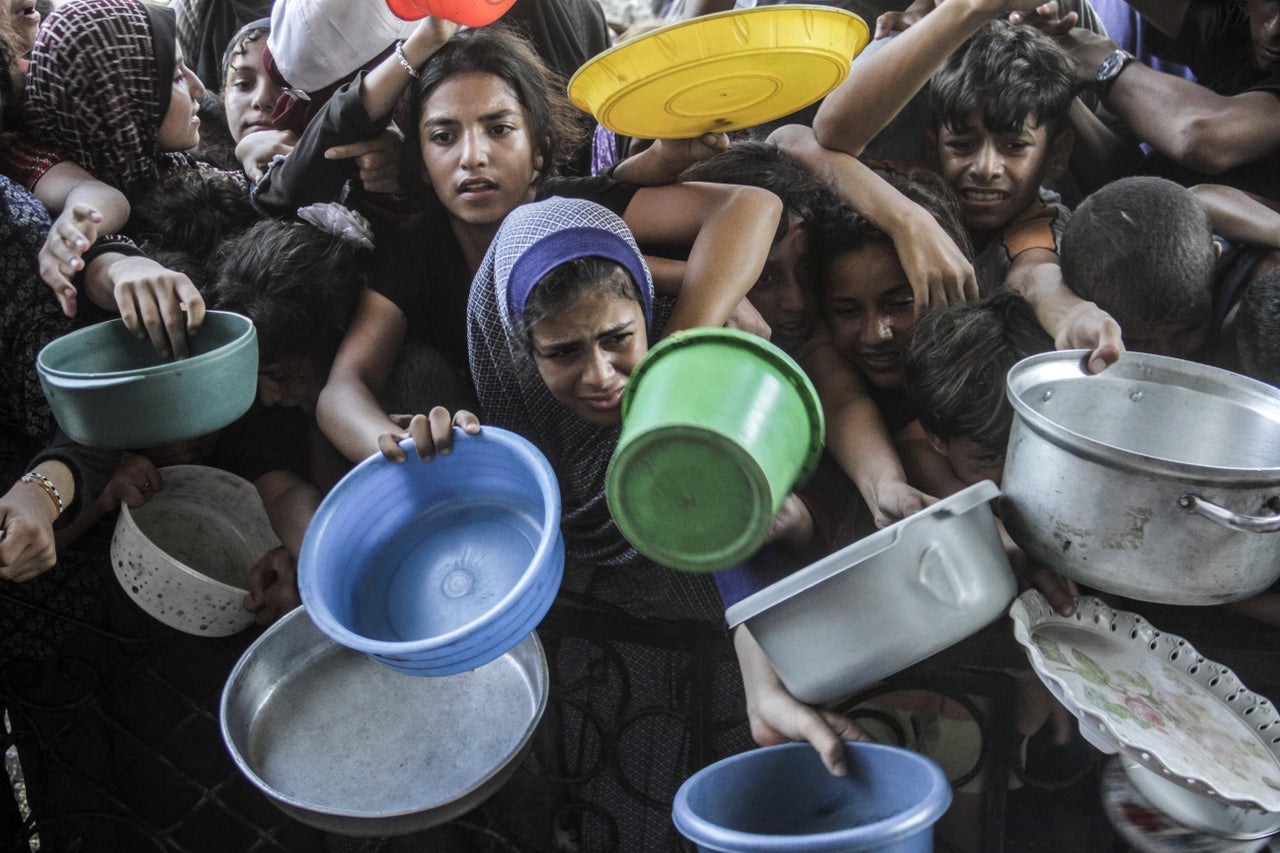 Displaced Palestinians wait on Aug. 14 to receive meals distributed by the Jabalia food bank in the northern Gaza Strip.