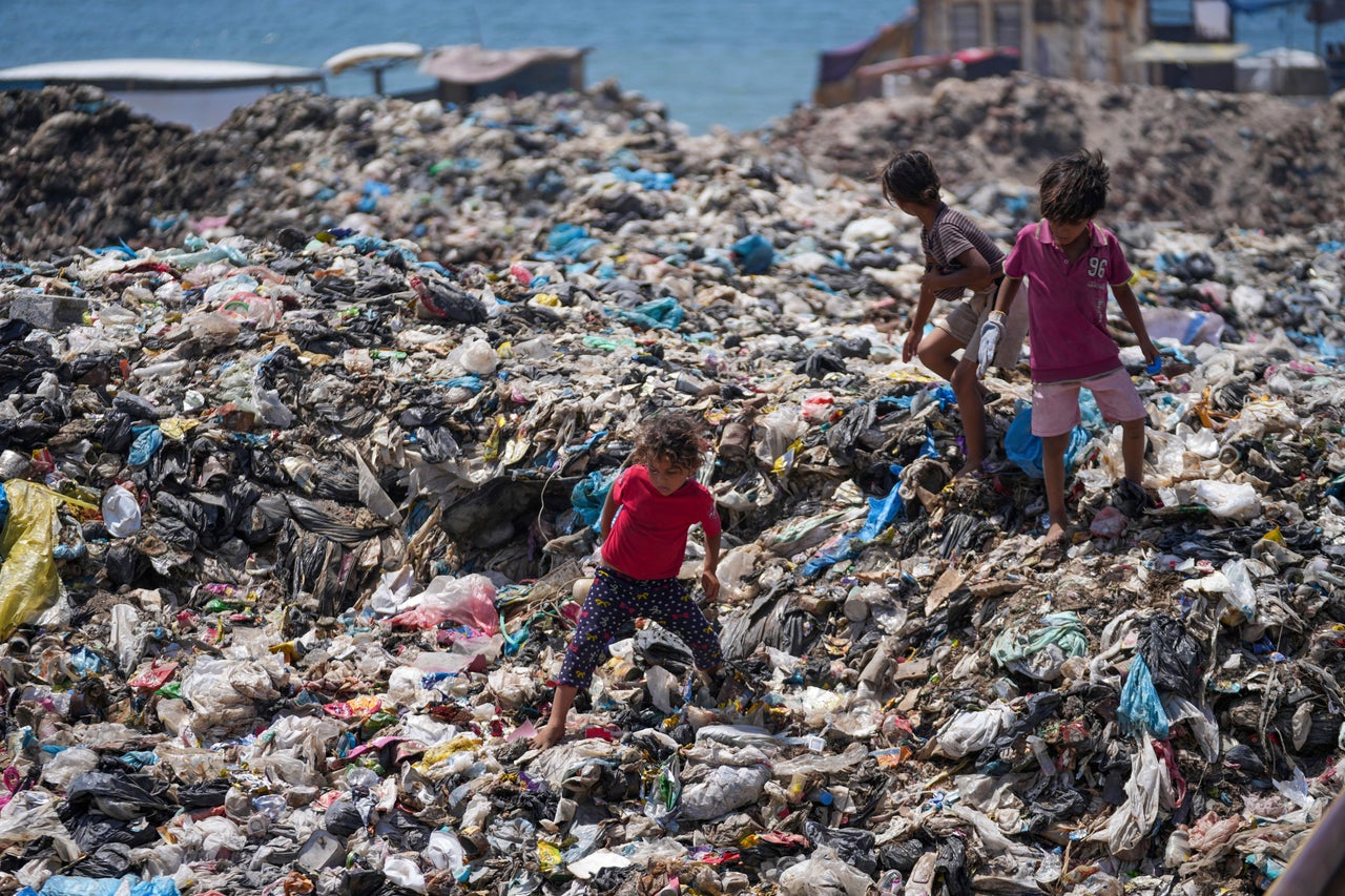 Palestinian children sort through trash on June 20 at a landfill in Nuseirat refugee camp in Gaza. Israel's war in Gaza has decimated the sanitation system while displacing most of the population, leaving many Palestinians in tent camps near contaminated water and growing piles of garbage.