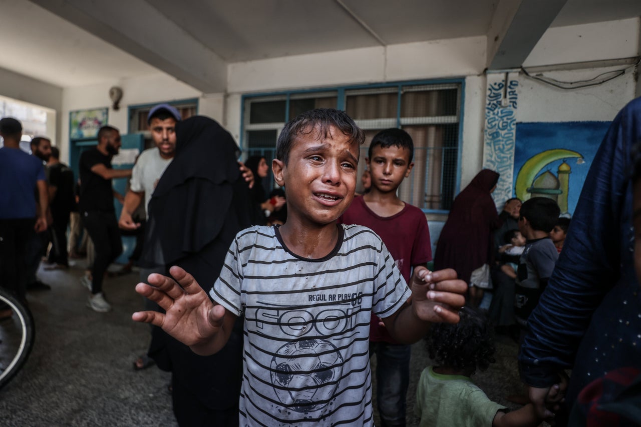 A Palestinian child cries on June 16 after Israeli fighter jets hit a U.N. relief agency school, killing and injuring many in Deir al-Balah, Gaza.