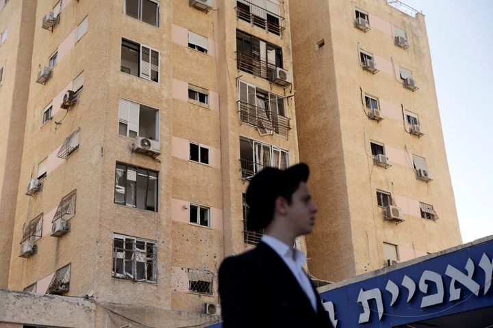 A man looks on in front of a residential building hit by a rocket on October 8, 2024 in Kiryat Yam near Haifa, Israel. Dozens of rockets were fired at northern Israel from Lebanon earlier today, according to the Israeli army. (Photo by Amir Levy/Getty Images)