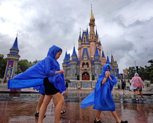 Guests at the Magic Kingdom at Walt Disney World brave wind and rain as bands of weather from Hurricane Debby pass through Central Florida on Aug. 5.