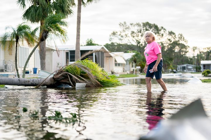 Eine Frau geht nach dem Hurrikan Milton am 10. Oktober 2024 in Osprey, Florida, eine überflutete Straße entlang. Der Hurrikan traf als Hurrikan der Kategorie 3 im Siesta Key-Gebiet auf Land. (Foto von Sean Rayford/Getty Images)