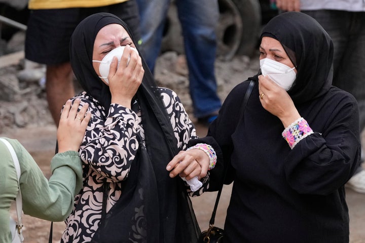 Γυναίκες κλαίνε τα συντρίμμια της πολυκατοικίας που άφησε πίσω του ο ισραηλινός βομβαρδισμός στη Βηρυτό το βράδυ της Πέμπτης (11 Οκτωβρίου 2024)