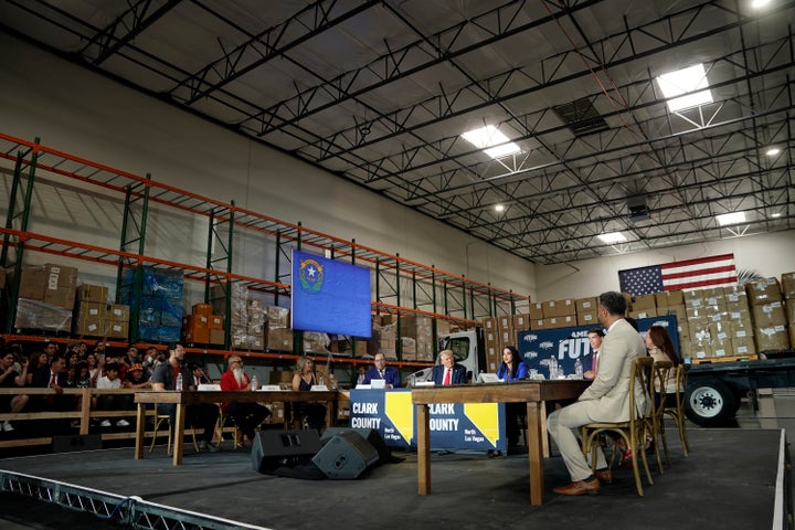 Elias Trujillo, left, listens with others at a campaign event for republican presidential nominee former President Donald Trump, center, Saturday, Oct. 12, 2024, in North Las Vegas. (AP Photo/Lucas Peltier)