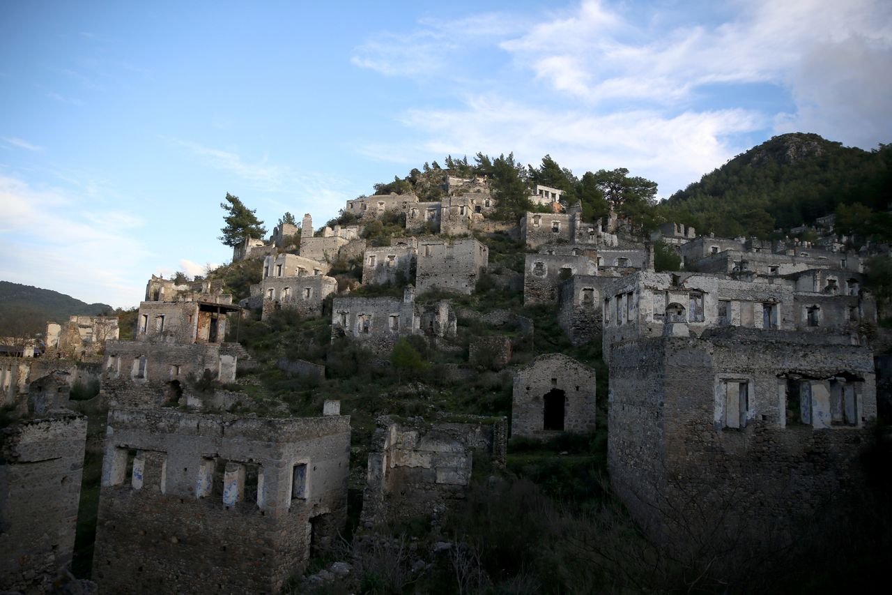 MUGLA, ΤΟΥΡΚΙΑ - 6 ΙΑΝΟΥΑΡΙΟΥ: Άποψη από το Kayakoy, γνωστό ως "χωριό-φάντασμα" στη Μούγλα της Τουρκίας στις 6 Ιανουαρίου 2024. Τα μουσεία και οι αρχαιολογικοί χώροι της πόλης, ένα από τα σημαντικότερα τουριστικά κέντρα της Τουρκίας, φιλοξένησαν πέρυσι 1 εκατομμύριο 164 χιλιάδες 151 επισκέπτες. Υποδεχόμενη εκατομμύρια τουρίστες, η Μούγλα ξεχωρίζει επίσης με τον ιστορικό της πλούτο. Το Μουσείο Υποβρύχιας Αρχαιολογίας του Μπόντρουμ, που βρίσκεται στο Κάστρο του Μπόντρουμ, ήταν το μουσείο με τις περισσότερες επισκέψεις, ενώ οι βραχώδεις τάφοι Amintas του Φετιγιέ και το Kayakoy ήταν οι αρχαιολογικοί χώροι με τις περισσότερες επισκέψεις. (Φωτογραφία: Ali Riza Akkir/Anadolu via Getty Images)