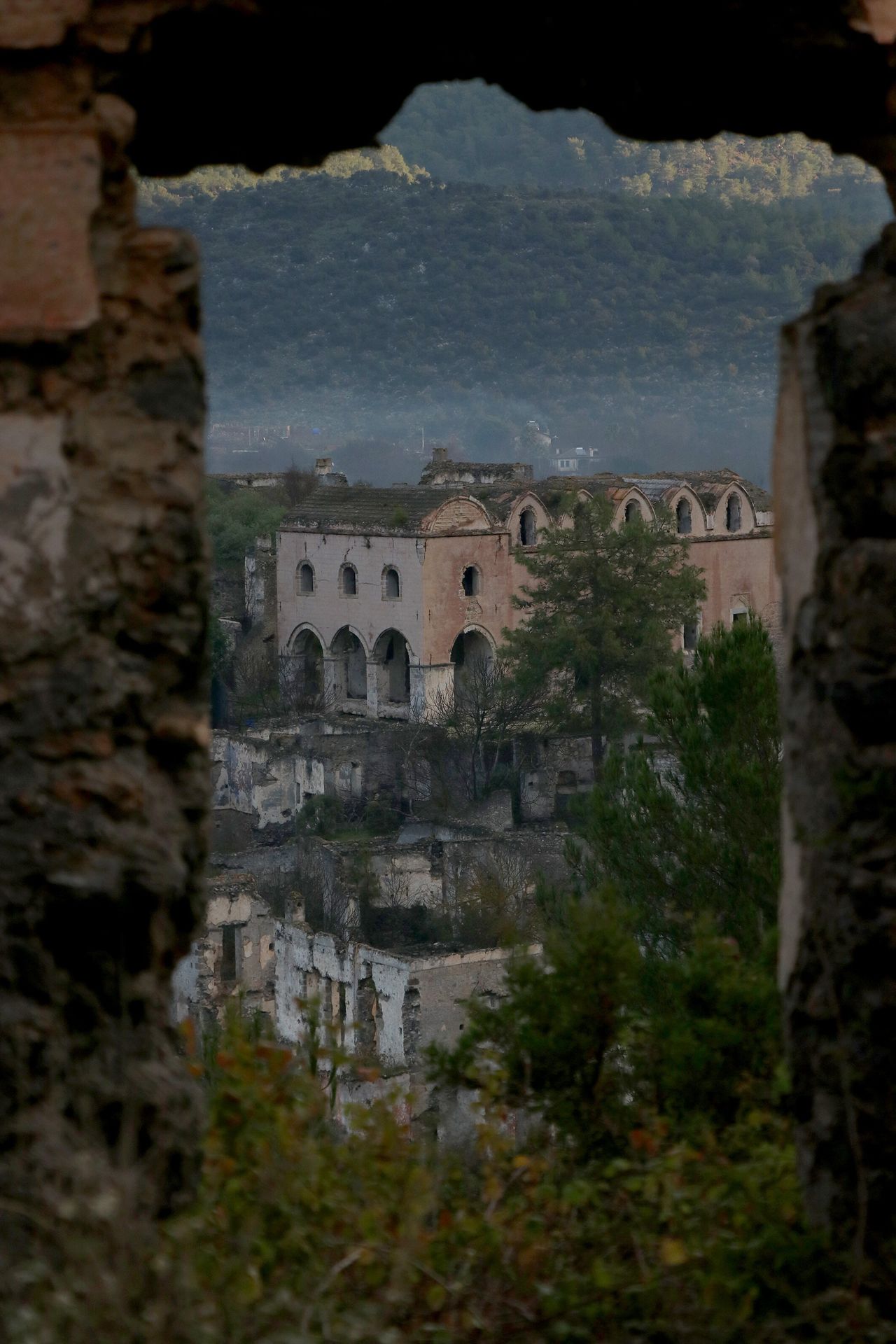 MUGLA, ΤΟΥΡΚΙΑ - 19 ΙΑΝΟΥΑΡΙΟΥ: Άποψη του Kayakoy, ενός χωριού που εγκαταλείφθηκε πριν από 100 χρόνια, γνωστού και ως "πόλη-φάντασμα" στη Μούγλα της Τουρκίας στις 19 Ιανουαρίου 2023. Ένα από τα σημαντικότερα τουριστικά αξιοθέατα της περιοχής με πάνω από 110 χιλιάδες επισκέπτες πέρυσι, το χωριό αποτελείται από σχεδόν 400 σπίτια, 2 εκκλησίες και μερικά παρεκκλήσια. (Φωτογραφία: Ali RÄ±za Akkir/Anadolu Agency via Getty Images)