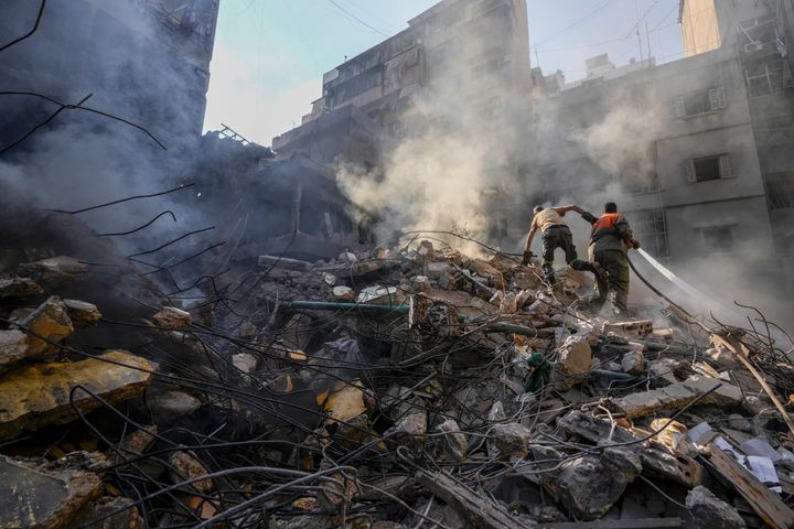 Rescue workers search for victims at the site of Thursday's Israeli airstrike in Beirut, Lebanon, Friday, Oct. 11, 2024.