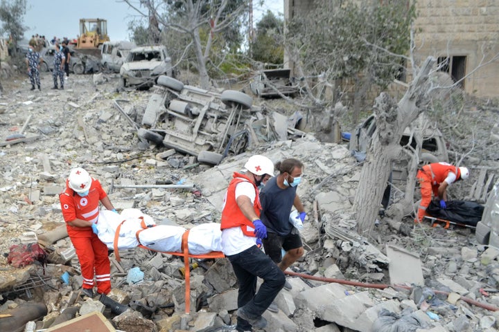 Paramedics with the Lebanese Red Cross transport a body unearthed from the rubble at the site of an Israeli airstrike targeting the northern Christian-majority village of Aito, on October 14, 2024.