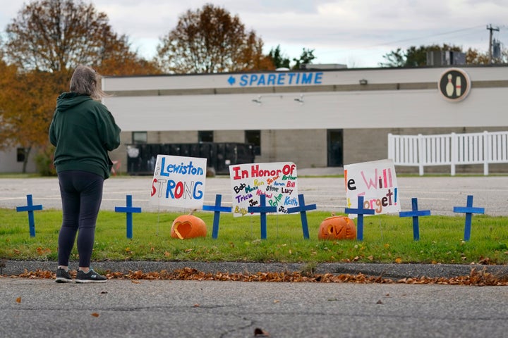 A woman visits a makeshift memorial outside Sparetime Bowling Alley, the site of a mass shooting, Oct. 28, 2023, in Lewiston, Maine.