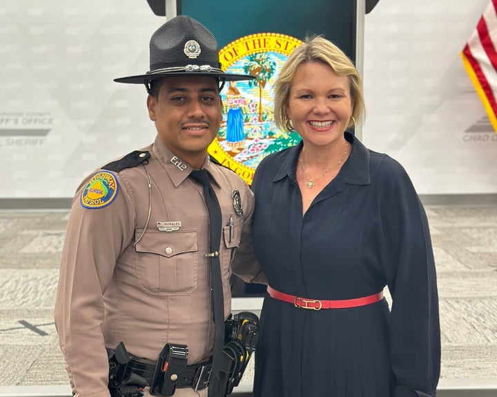 State's Attorney Suzy Lopez is seen with Florida Highway Patrol Trooper Orlando Morales, who is credited with rescuing the dog.